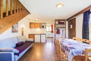 een woonkamer met een bank en een tafel en een keuken bij Residence La Crete du Berger - maeva Home in La Joue du Loup