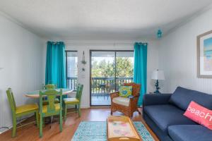 sala de estar con sofá azul, mesa y sillas en Forever Summer en Tybee Island