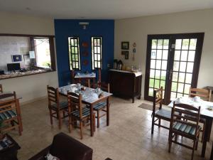 una sala da pranzo con tavolo, sedie e pareti blu di Pousada Mar e Marés a Rio das Ostras