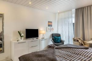a bedroom with a bed and a tv and a chair at Ferienwohnung Urs in Schönwald +22 photos