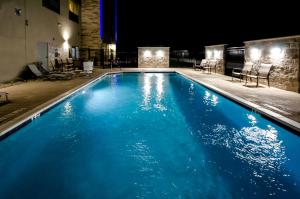 a swimming pool at night with blue water at Holiday Inn Express & Suites Taylor, an IHG Hotel in Taylor