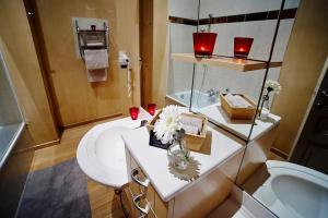 a bathroom with a sink and a toilet and candles at B&B Au Clair Obscur in Verviers