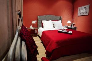 ヴェルヴィエにあるB&B Au Clair Obscurの赤い壁のベッドが備わるホテルルームです。