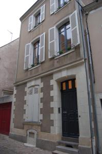 a building with a black door and windows at Suit'Home Jacobins in Angers
