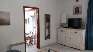 ein Wohnzimmer mit einem Schrank mit einem TV und einem Spiegel in der Unterkunft Casetta in Ortiporio