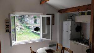 eine Küche mit einem Fenster in einer Küche mit einem Tisch in der Unterkunft Casetta in Ortiporio