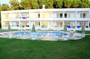 ein großes weißes Gebäude mit Stühlen und einem Pool in der Unterkunft Aroma Butik Hotel in Kızılot