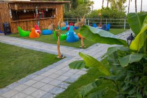 einen Kinderspielplatz mit buntem Plastikspielzeug auf dem Rasen in der Unterkunft Aroma Butik Hotel in Kızılot