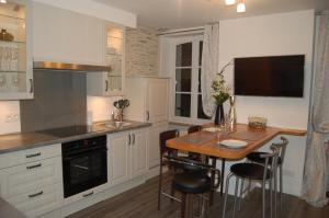 cocina con mesa de madera y mesa pequeña con sillas en Suit'Home Jacobins, en Angers