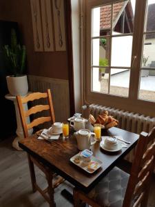 uma mesa de madeira com comida para o pequeno almoço em Hôtel Restaurant Le Moulin de la Renne Adults Only proche Zoo de Beauval em Thésée