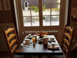 - une table avec de la nourriture et une fenêtre dans la chambre dans l'établissement Hôtel Restaurant Le Moulin de la Renne Adults Only proche Zoo de Beauval, à Thésée