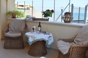 una mesa con una botella de vino y dos sillas en In Riva al Mare da Franca, en Trabia