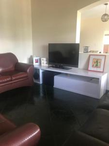 un soggiorno con scrivania, TV e divano di PARAÍSO ECOLÓGICO- REGIÃO ATIBAIA a San Paolo