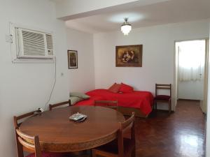 1 dormitorio con mesa y 1 cama con manta roja en Peatonal Sarmiento en Mendoza