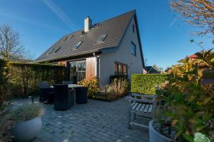 a house with a patio with a table and chairs at Welcome in - Borne 56a, Zoutelande in Zoutelande