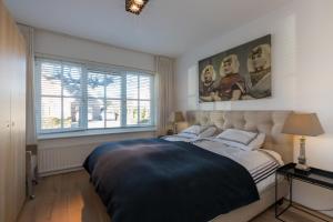 a bedroom with a large bed and a window at Welcome in - Borne 56a, Zoutelande in Zoutelande