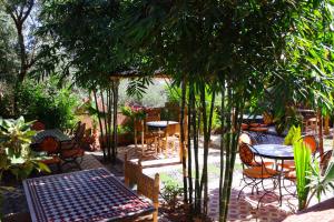 patio ze stołem, krzesłami i drzewami w obiekcie Dar Diafa Kaltom w mieście Ouzoud