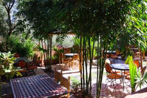 a patio with a table and chairs and trees at Dar Diafa Kaltom in Ouzoud