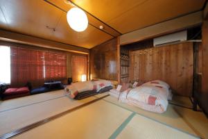 two beds in a room with wooden walls at Oyado Sanjyo-Machiya - Vacation STAY 96740 in Kyoto