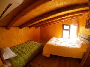 - une chambre avec 2 lits et une fenêtre dans l'établissement Hospedaje y Agrocamping Relmucura, à Melipeuco