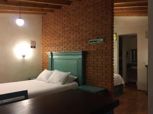 a bedroom with a bed and a brick wall at Hacienda Soltepec Suites Campo de Golf in Huamantla +20 photos