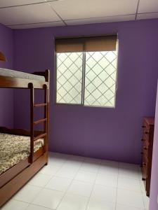 a purple room with a bunk bed and a window at Beach house in Punta Carnero Salinas / Casa in Salinas