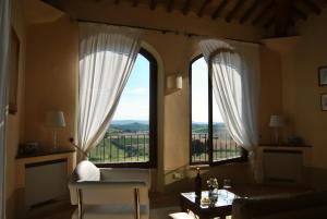 sala de estar con 2 ventanas grandes, mesa y sillas en Villa La Valiana - Full Estate in Montepulciano - HEATED POOL, en Valiano