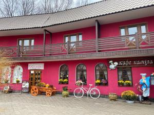 a pink building with a bike parked in front of it at Готель-ресторан Каміла in Polyana