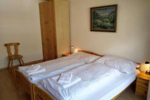 Un dormitorio con una cama blanca con una foto en la pared en Catherina 42 en Leukerbad