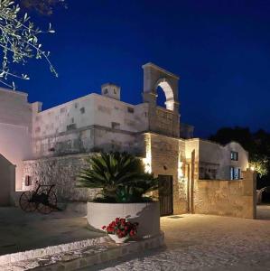 een groot stenen gebouw met 's nachts een klokkentoren bij B&b Aurasia in Ostuni