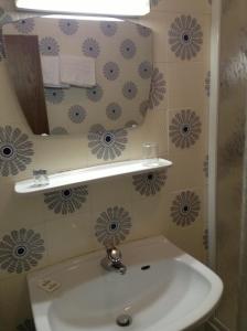 uma casa de banho com um lavatório e um espelho em Hotel Daniela em Merano