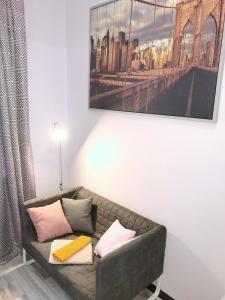 a couch in a living room with a picture on the wall at Апартаменты на Гончарной,11 in Saint Petersburg