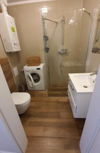 uma casa de banho com um chuveiro, um WC e um lavatório. em Apartamenty Waterline Ustronie Morskie em Ustronie Morskie