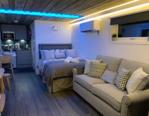 a living room with a bed and a couch at Royal Snug & Wee Snug Cabins in Kincardine OʼNeil