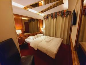 a small hotel room with a bed and a mirror at Rembrandtplein Hotel in Amsterdam