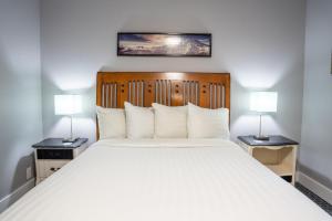 ein Schlafzimmer mit einem großen weißen Bett mit zwei Lampen in der Unterkunft Blue Elk Inn in Leavenworth