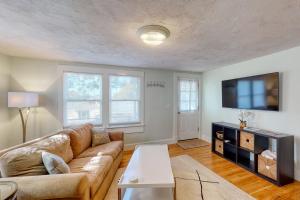 a living room with a couch and a flat screen tv at Wild Wood Way Cottage in Bar Harbor