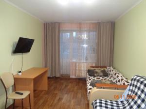 トムスクにあるUchebnaya 7 - 2 Bedroomの小さなリビングルーム(ソファ、テーブル付)