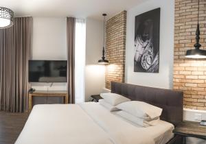 a bedroom with a white bed and a brick wall at Hotel Oui GO! in Trois-Rivières
