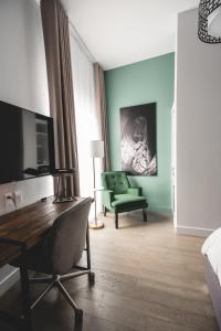 um quarto de hotel com uma secretária e uma cadeira verde em Hotel Oui GO! em Trois-Rivières