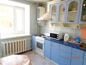 トムスクにあるАпартаменты 2-к Иркутский тракт 12の小さなキッチン(青いキャビネット、電子レンジ付)