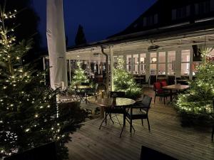 eine Terrasse mit Weihnachtsbäumen, Tischen und Stühlen in der Unterkunft Hotel Jean-Jacques Rousseau in La Neuveville