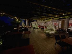un patio con mesas y sillas por la noche en Hotel Jean-Jacques Rousseau, en La Neuveville