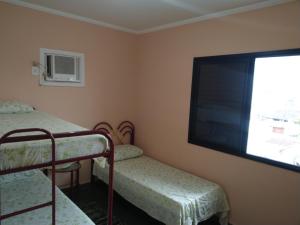 a bedroom with two bunk beds and a flat screen tv at Apartamento em Ubatuba in Ubatuba