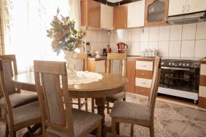 a kitchen with a wooden table with chairs and a dining room at Casa Relax in Sânâteşti