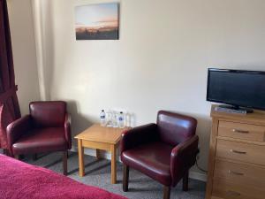 a room with two chairs and a table with a tv at The Wyche Inn in Great Malvern