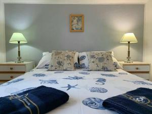 un letto con piumone blu e bianco e 2 lampade di Fresh Apartments Dar Orlic a Trogir