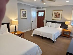 a bedroom with two beds and two lamps at Coronado Island Inn in San Diego