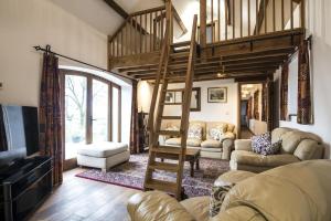 een woonkamer met een hoogslaper en een bank bij Orchard Cottage - Luxurious Barn Conversion - Beavers Hill in Manorbier