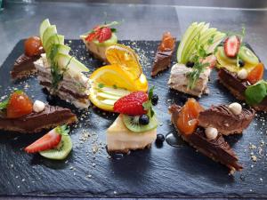 a plate of desserts with fruit on top at Hotel Minaliat Vek in Shumen